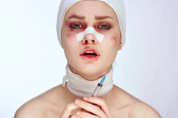Paciente femenina con moretones en la cara vendados jeringa en mano analgésicos estilo de vida estudio — Foto de Stock