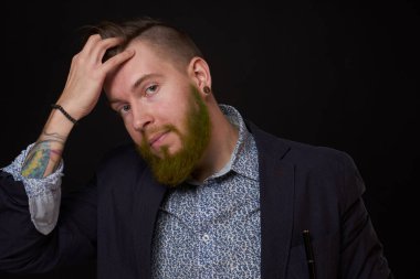 Ceketli, sakallı, şık bir iş adamı.