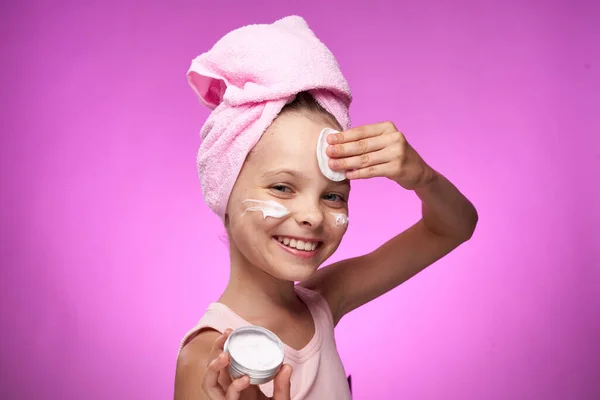 Девушка с полотенцем на голове косметические украшения крупным планом фиолетовый фон — стоковое фото