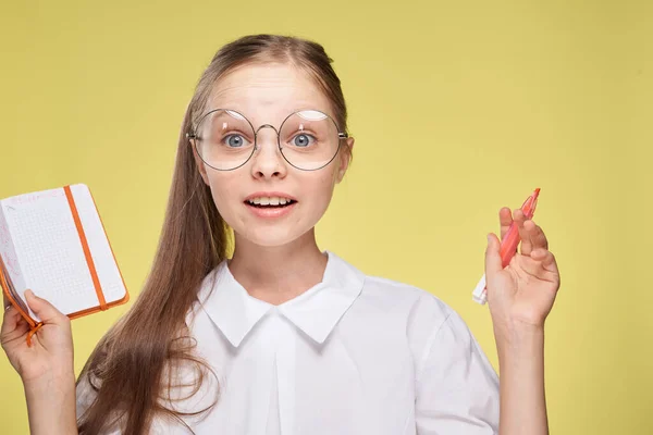 Estudante com livro didático em mãos aprendendo infância fundo amarelo — Fotografia de Stock