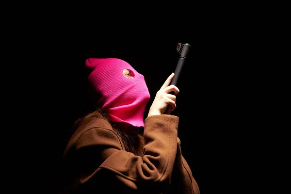 빨간 마스크를 쓰고 총기 범죄 조직 갱스터의 어두운 배경을 위협하는 여성 — 스톡 사진