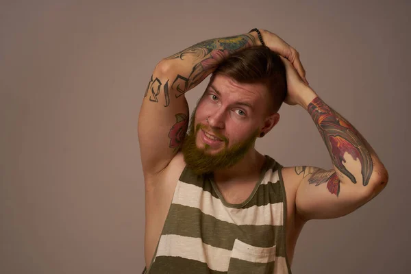 Красивий чоловік з татуюваннями на руках модні зачіски емоції — стокове фото