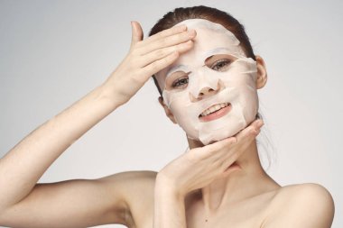 Güzel bir kadın çıplak omuzlarıyla maske takar.