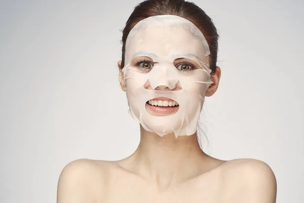 Wanita emosional masker wajah kosmetik close-up latar belakang cahaya — Stok Foto