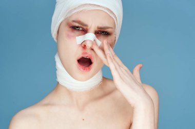 Yüzü bandajlı bir kadının portresi stüdyo yaşam tarzını beğenmeyen çıplak omuzlarını çürütür.