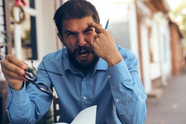 Hombre de negocios en camisa azul en el papeleo de trabajo de café — Foto de Stock