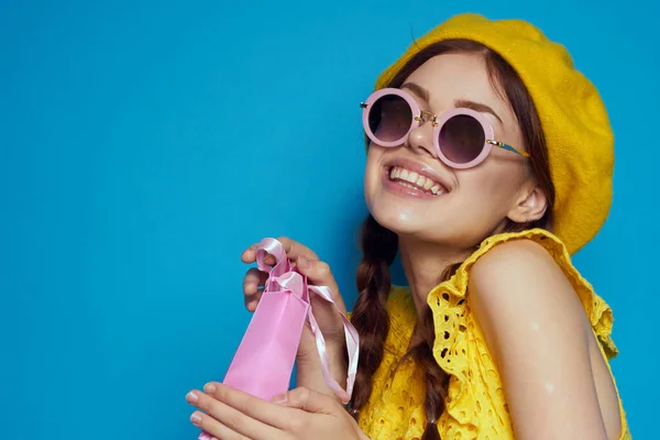 Glamoureuze vrouw in een gele hoed Shopaholic mode stijl blauwe achtergrond — Stockfoto