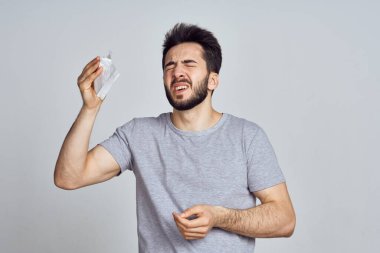 Beyaz tişörtlü sakallı adam elleriyle el kol hareketi yapıyor.