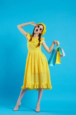 Sarı şapkalı alımlı çekici bir kadın. Alışverişe özgü bir tarzı var.
