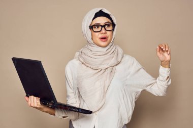 Laptop öğrenme teknolojisi olan Müslüman kadın.