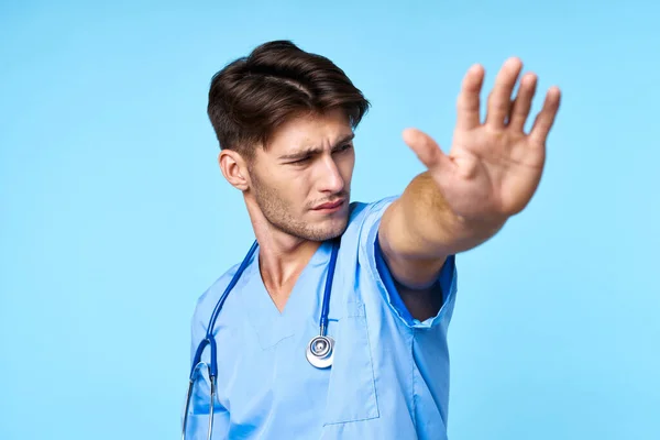 Άνδρας με ιατρική στολή ασθενής θεραπεία νοσοκομειακή ιατρική μπλε φόντο — Φωτογραφία Αρχείου