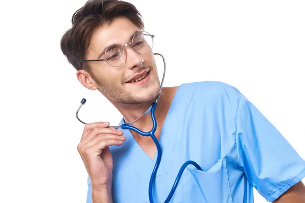 Médico masculino usando gafas estetoscopio posando fondo claro — Foto de Stock