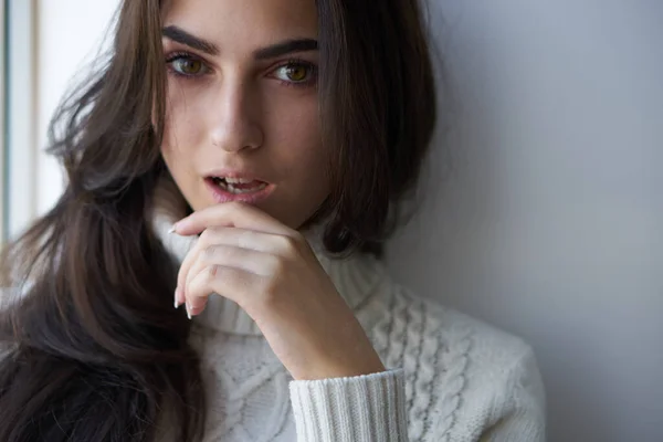 Mujer bonita en suéter blanco cerca de la ventana solo — Foto de Stock