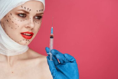 Ellerinde mavi eldiven şırıngası olan kadın hasta stüdyo yaşam tarzında yüz kaldırma biçiminde.