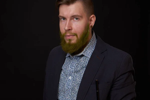 Hombre de negocios de moda en una chaqueta con una barba posando — Foto de Stock