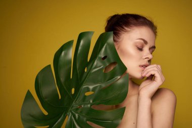 Neşeli kadın palmiye yaprağı çıplak omuzlar sarı arka plan