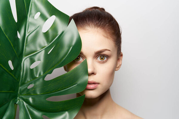 attractive woman palm leaf bare shoulders studio model