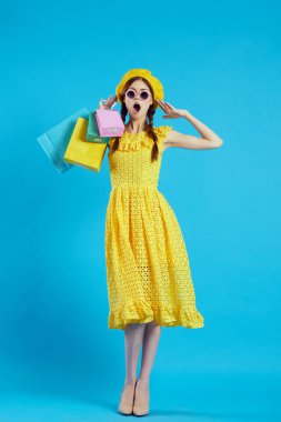 Güneş gözlüğü takan gülümseyen bir kadın alışveriş modası yapıyor.