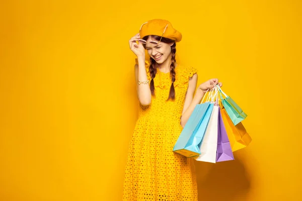 Χαρούμενη γυναίκα σε ένα κίτρινο καπέλο Shopaholic στυλ μόδας μοντέλο στούντιο — Φωτογραφία Αρχείου