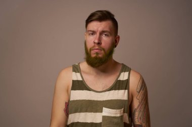 Kollarında dövmeleri olan yakışıklı bir adam. Saç stili duyguları var.