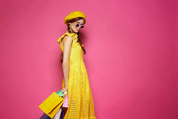 stock image cheerful woman with multicolored bags posing pink background