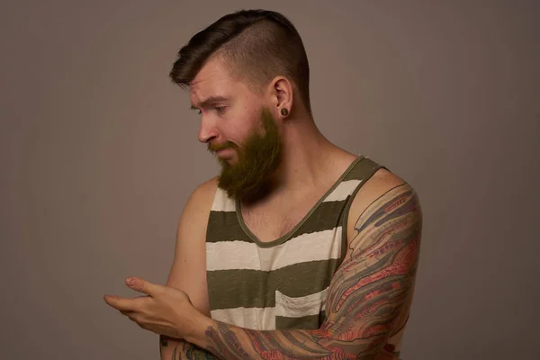 Modny mężczyzna z tatuażami na ramionach stylowa fryzura self-confidence studio — Zdjęcie stockowe