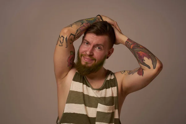 ハンサムな男でタトゥーのある彼の腕のファッショナブルな髪型の感情 — ストック写真