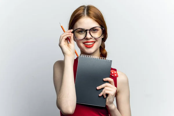 Femme gaie avec des lunettes robe rouge bloc-notes travail — Photo