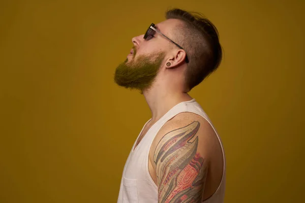 Hombre en una camiseta blanca tatuajes en sus brazos gafas de moda estilo moderno — Foto de Stock