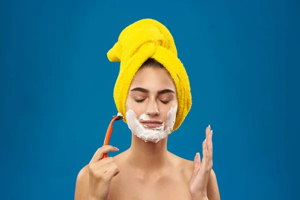 Mooie vrouw met een gele handdoek op zijn hoofd scheren — Stockfoto