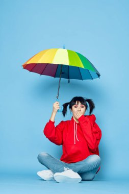 Kırmızı tişörtlü neşeli kadın gökkuşağı renkli şemsiye moda