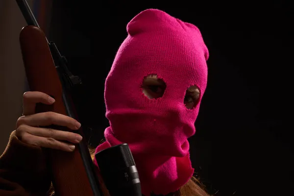 Женщина в гламурной розовой маске дробовик позирует черный фон — стоковое фото