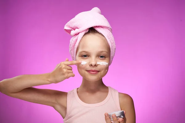 Дівчина з рушником на голові косметичні прикраси крупним планом фіолетовий фон — стокове фото