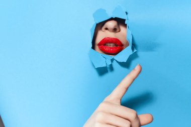 Poster mavisi stüdyo arka planındaki deliklerden bakan bir kadın.