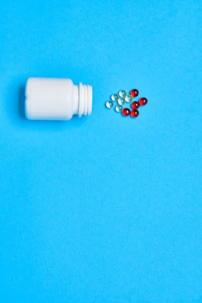 Píldoras multicolores tratamiento atención médica fondo azul — Foto de Stock