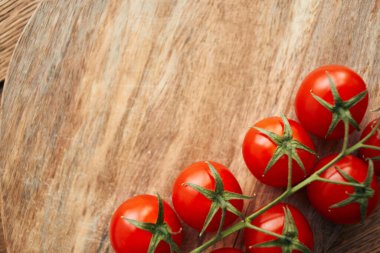 Tahta bir mutfak malzemesinin dalındaki kiraz domatesleri taze gıdalar.