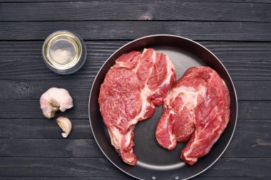 Kızartma tavasında biftek. Mutfak ahşap masa.