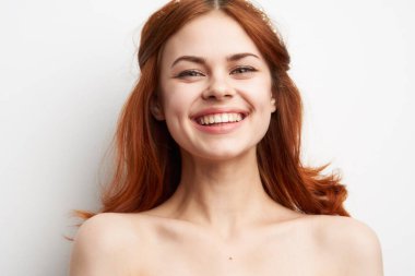 Çıplak omuzlu, neşeli bir kadın. Saç stili, göz alıcı.