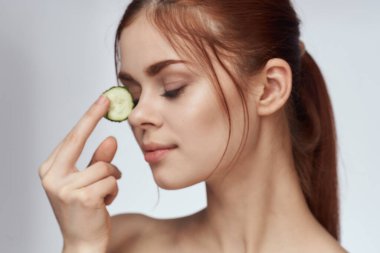 Elinde salatalıklar, kozmetik vitaminleri olan neşeli kadın.