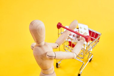 Tahta kukla, sarı arka planda.