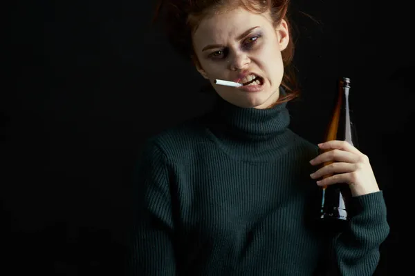 Vrouw met fles alcohol blauwe plekken onder de ogen veranderingen depressie donkere achtergrond — Stockfoto