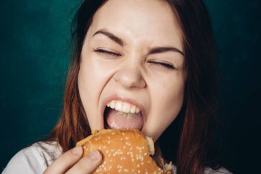Hamburger yiyen bir kadın.