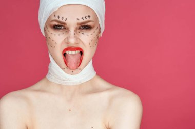 Mavi eldivenli bir kişi kırmızı dudaklı yüz yenileme ameliyatı yakın plan.