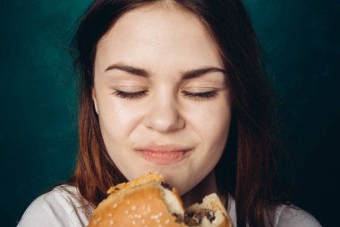 Hamburger yiyen bir kadın.