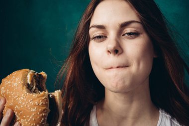 Hamburger yiyen bir kadın.