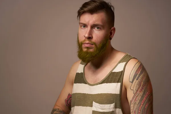 Бородатий чоловік у смугастій футболці татуювання окулярів на його руках мода — стокове фото