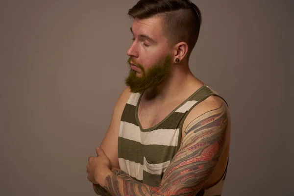 ファッショナブルな男とタトゥーのある彼の腕スタイリッシュな髪型自信スタジオ — ストック写真