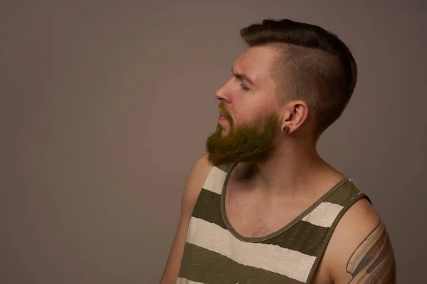 ファッショナブルな男とタトゥーのある彼の腕スタイリッシュな髪型自信スタジオ — ストック写真