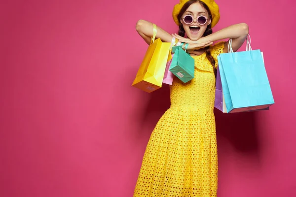 Mulher sorridente em um chapéu amarelo Shopaholic modelo de estúdio de estilo de moda — Fotografia de Stock