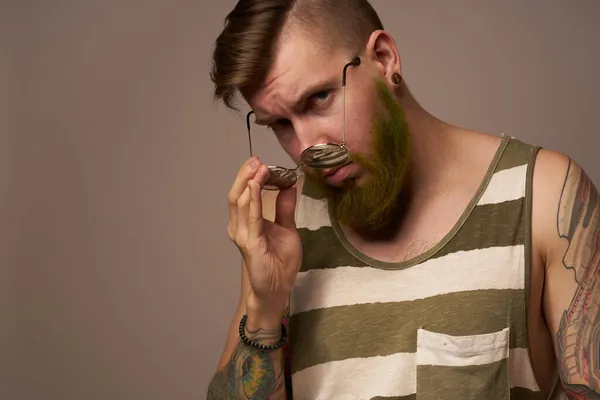 Brodaty mężczyzna w paski koszulka okulary tatuaż na jego ręce moda — Zdjęcie stockowe